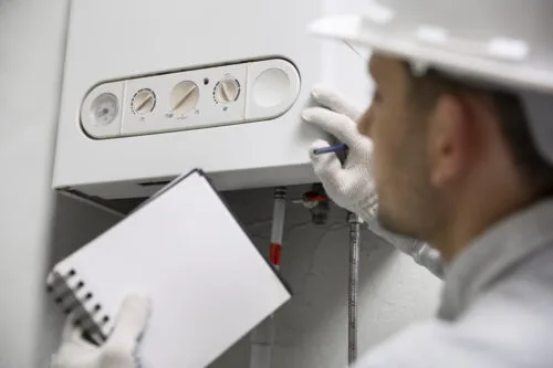Bonus caldaia 2024. L'immagine rappresenta un tecnico mentre sta controllando una caldaia